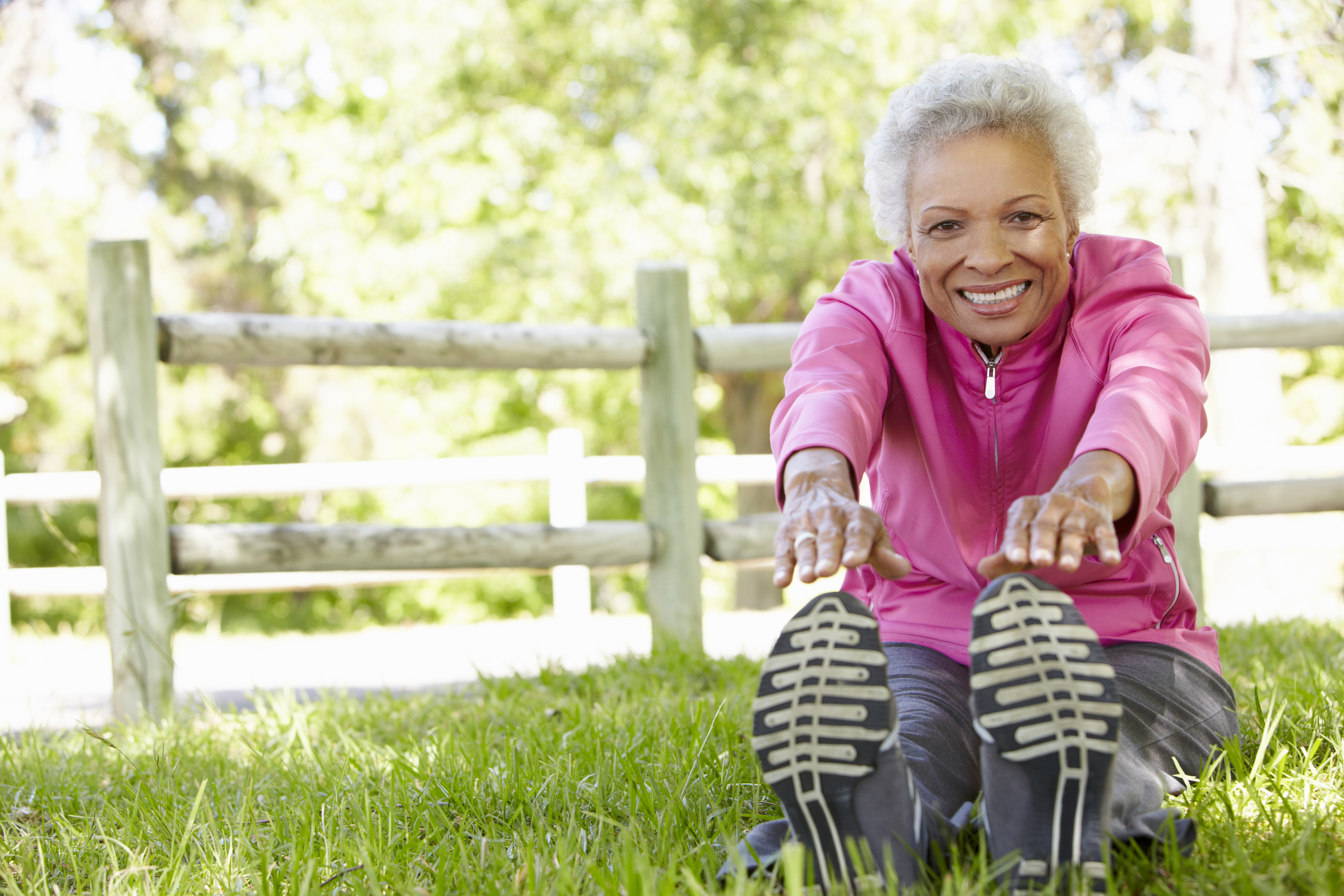 senior woman stretching in a park