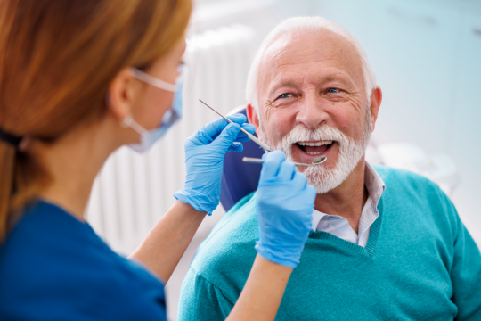 Happy senior man receiving dental examination.